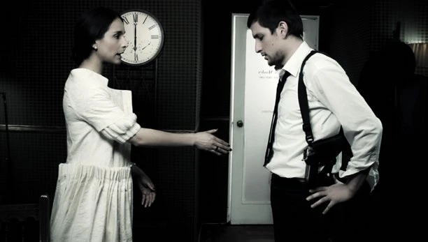 Escena en blanco y negro: dos personajes frente a frente en una oficina