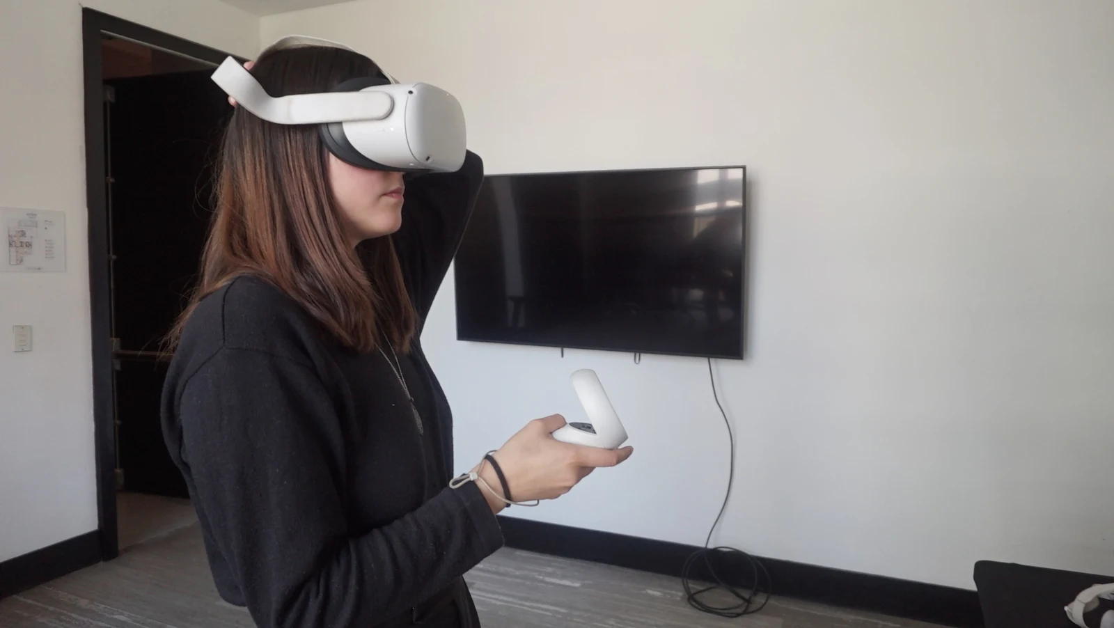 Participante utiliza visor y control VR durante una actividad